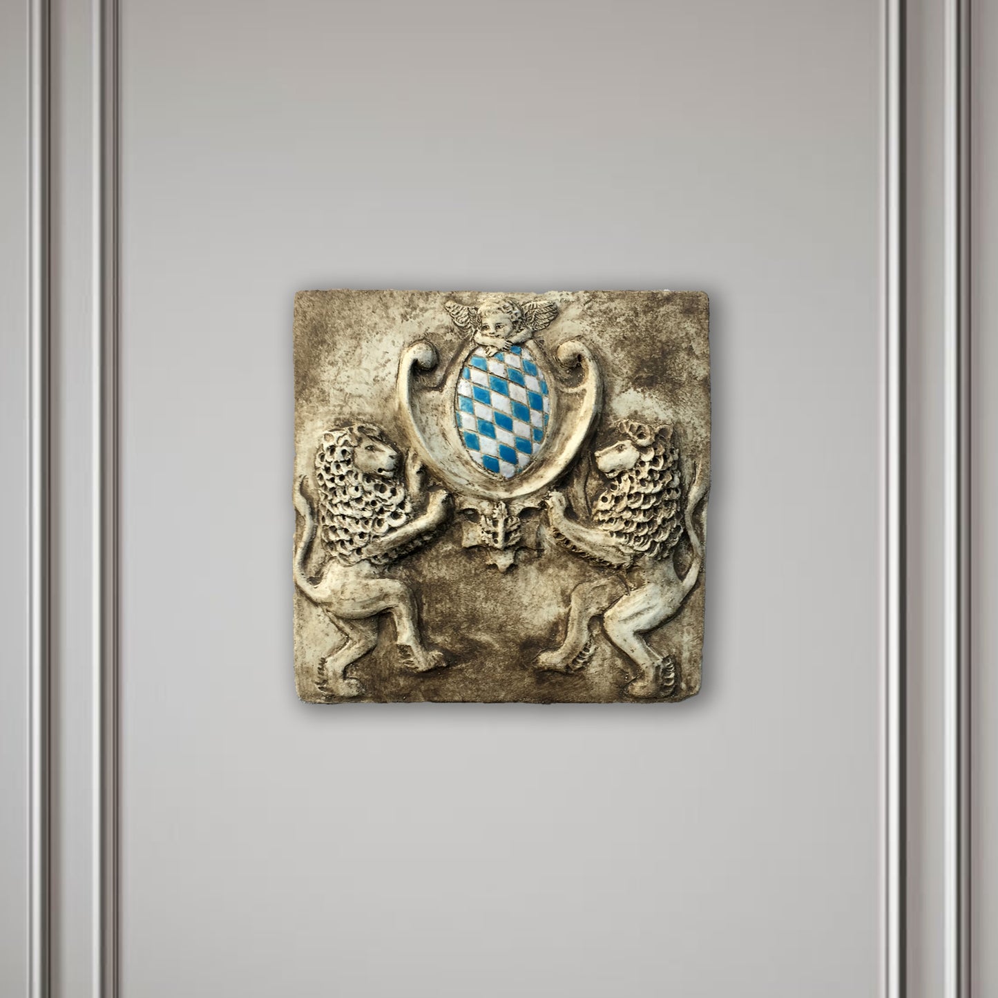 Zwei Löwen halten das Bayerische Wappen. Bemaltes Wandrelief auf Keramik