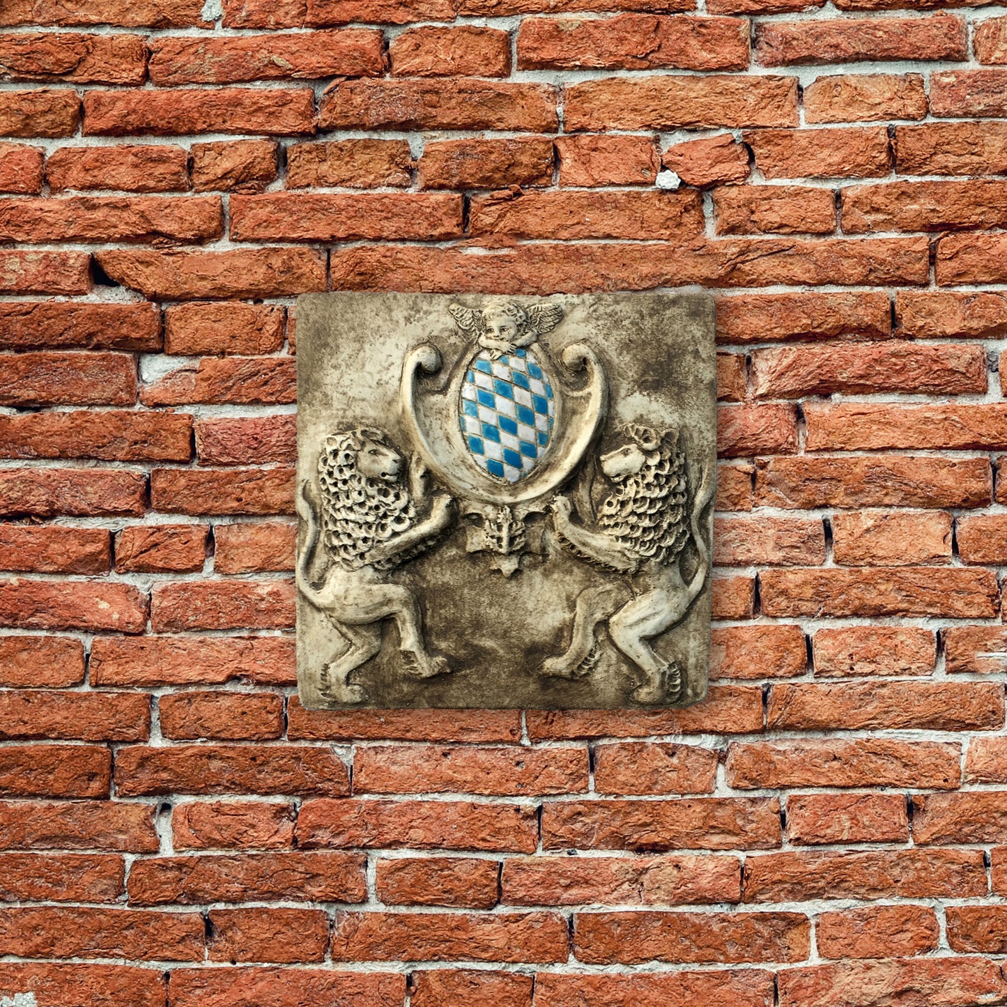Zwei Löwen halten das Bayerische Wappen. Bemaltes Wandrelief auf Keramik