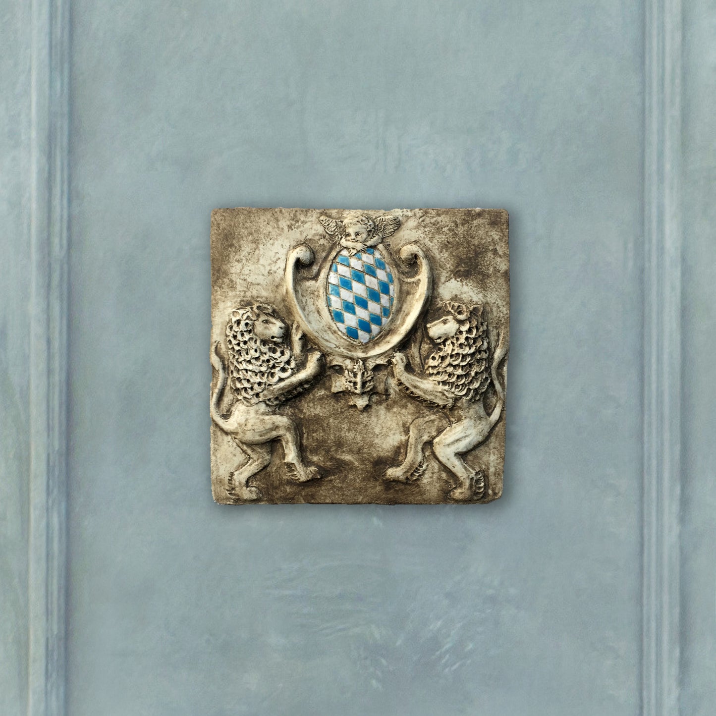 Zwei Löwen halten das Bayerische Wappen. Bemaltes Wandrelief auf Keramik