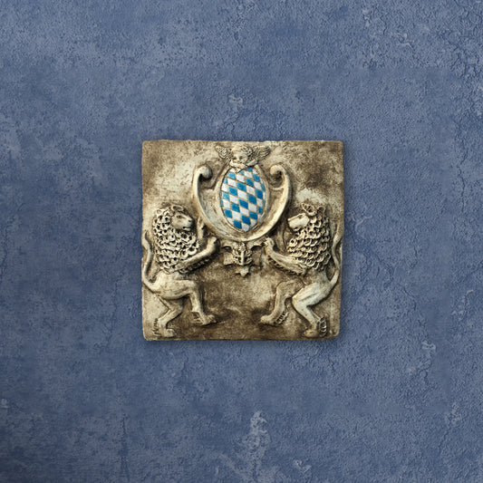 Zwei Löwen halten das Bayerische Wappen. Bemaltes Wandrelief auf Keramik